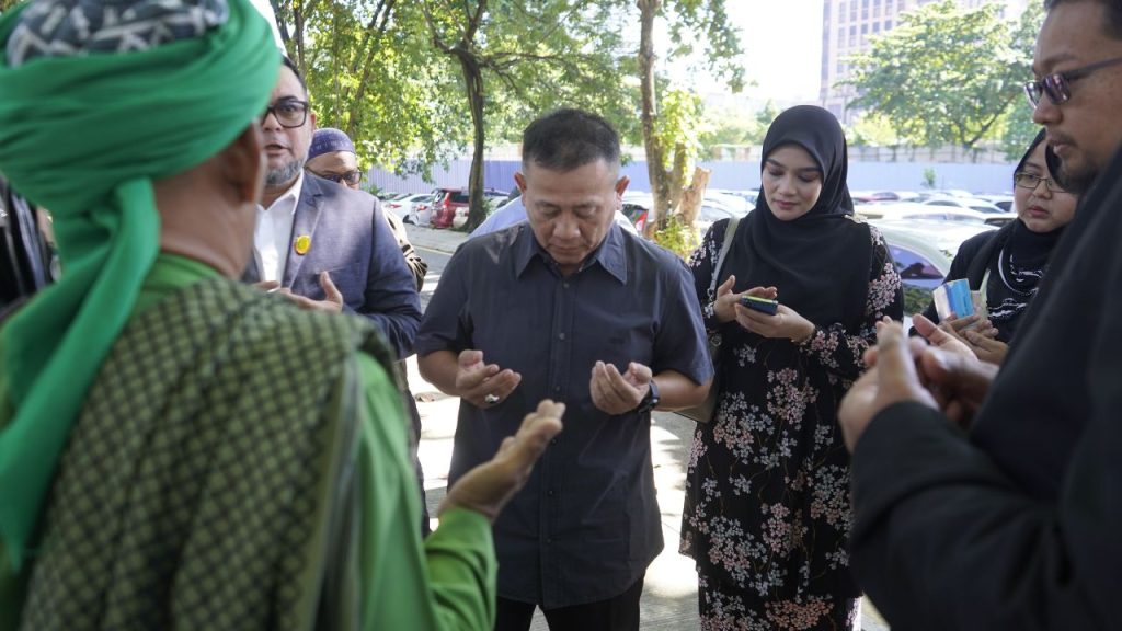 Nurul Fadzilah Kamaluddin menadah tangan berdoa memohon proses memberi keterangan kepada pihak polis berjalan dengan lancar.